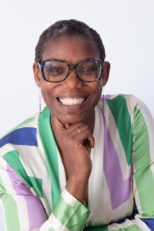 Jeune femme noire très souriante en tenue verte