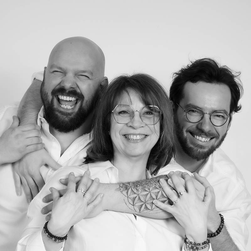 photo studio d'une mère et ses deux fils, tous 3 enlacés et heureux