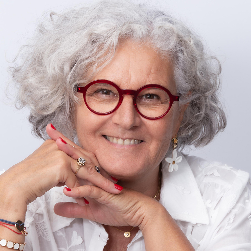 Femme cheveux gris très souriante lunettes rouges