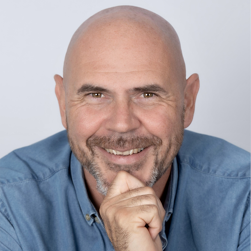 photo profil réseau d'un homme en chemise, main repliée posée sur son menton